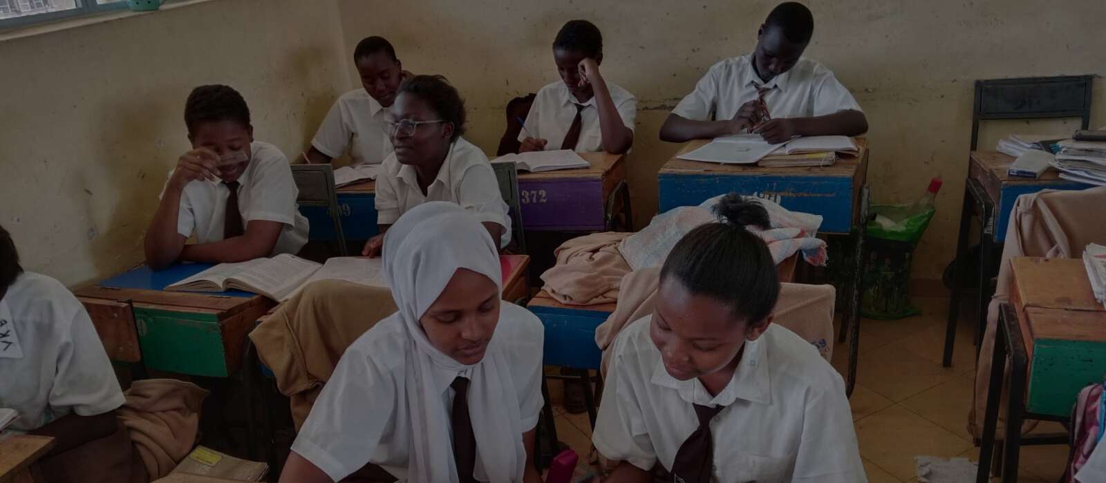A classroom scene in South Sudan, highlighting children learning together under protective measures for their safety.